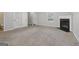 Bright living room featuring plush carpeting, fireplace, and an open transition to the dining area at 162 Watercress Ct, Stockbridge, GA 30281