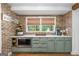 Cozy kitchenette boasts shaker-style cabinets, quartz countertops and a brick backsplash at 396 Ebenezer Rd, Fayetteville, GA 30215