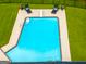 Aerial view of a backyard pool with lounge chairs and a diving board, surrounded by green grass and a black fence at 396 Ebenezer Rd, Fayetteville, GA 30215