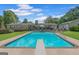 A large swimming pool with diving board, surrounded by lush landscaping and green grass at 396 Ebenezer Rd, Fayetteville, GA 30215
