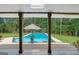 View through the patio columns of the in-ground swimming pool at 396 Ebenezer Rd, Fayetteville, GA 30215