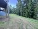 Sloped, grassy backyard with a dense tree line at 248 Webster Lake Dr, Temple, GA 30179
