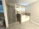 Modern bathroom featuring a glass shower, a soaking tub, and neutral colored tile at 248 Webster Lake Dr, Temple, GA 30179