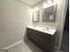 Bathroom featuring double sinks, framed mirrors, a gray vanity, and tiled floors at 248 Webster Lake Dr, Temple, GA 30179