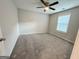 Bedroom featuring neutral walls, a ceiling fan, carpet, and a large window with blinds at 248 Webster Lake Dr, Temple, GA 30179