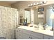 Well-lit bathroom featuring double vanity, large mirror, and shower with decorative curtain at 4790 Hwy 101 N, Rockmart, GA 30153