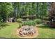 Secluded backyard featuring lush landscaping, mature trees, a shed, and a charming rock garden feature at 4352 Treeline Way, Douglasville, GA 30135