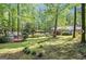 Expansive backyard with lush greenery, mature trees, a shed, and a covered structure, ideal for outdoor living at 4352 Treeline Way, Douglasville, GA 30135