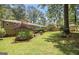 Well-manicured backyard with a large lawn, mature trees, and a charming garden with a wooden pergola at 4352 Treeline Way, Douglasville, GA 30135