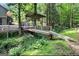 Scenic backyard featuring a quaint wooden bridge over a stream, with a covered pavilion in a wooded setting at 4352 Treeline Way, Douglasville, GA 30135