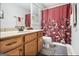 Cozy bathroom featuring wood cabinets, a floral shower curtain, and neutral walls at 4352 Treeline Way, Douglasville, GA 30135