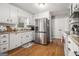 Bright kitchen with white cabinets, modern stainless steel appliances, and hardwood floors at 4352 Treeline Way, Douglasville, GA 30135