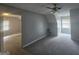 Finished attic space with two windows, neutral carpet, and a ceiling fan for added comfort at 4680 Duval Point Sw Way, Snellville, GA 30039