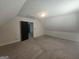 Large attic room with neutral carpet, door to closet/storage, and potential for versatile use at 4680 Duval Point Sw Way, Snellville, GA 30039
