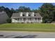 Inviting home features a covered front porch, lush green lawn, and mature trees, creating a serene setting at 4680 Duval Point Sw Way, Snellville, GA 30039