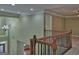 Hallway with decorative wood and iron railing overlooks the foyer with chandelier and decorative glass front door at 834 Chalet Hills, Mcdonough, GA 30253