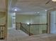 Hallway with decorative wood and iron railing overlooks the floor with neutral colored carpeting and light green walls at 834 Chalet Hills, Mcdonough, GA 30253