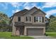 Charming two-story home featuring a brick front, gray siding, and attached two-car garage at 10422 Trellis Lane (Lot 38), Hampton, GA 30228