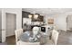 Bright kitchen with pantry, stainless steel fridge, and dining area with a round wooden table at 10422 Trellis Lane (Lot 38), Hampton, GA 30228