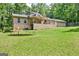 Home exterior with large, green backyard and trampoline, framed by trees, offering a serene outdoor space at 351 Weldon Rd, Palmetto, GA 30268