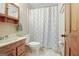 Cozy bathroom showcasing a light wood vanity with sink, toilet, and shower with patterned curtain at 351 Weldon Rd, Palmetto, GA 30268
