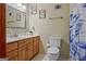 Bathroom featuring a vanity with wood cabinets, a mirror, and a toilet with a blue patterned shower curtain at 351 Weldon Rd, Palmetto, GA 30268