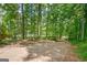 Gravel driveway surrounded by a lush forest of mature trees and greenery at 351 Weldon Rd, Palmetto, GA 30268