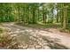 Serene gravel driveway surrounded by towering trees, leading to a secluded home at 351 Weldon Rd, Palmetto, GA 30268