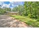 Charming one-story home with a deck and a lush, green lawn surrounded by mature trees at 351 Weldon Rd, Palmetto, GA 30268