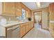 This well-lit kitchen features light wood cabinetry, stainless appliances and tile flooring at 351 Weldon Rd, Palmetto, GA 30268