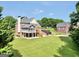 Expansive backyard with lush green grass and the home with screened porch and wooden deck at 106 Big Cotton Trl, Mcdonough, GA 30252