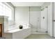 Bright bathroom with a soaking tub, glass enclosed shower, and vanity with sink at 106 Big Cotton Trl, Mcdonough, GA 30252
