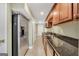 Galley style kitchen featuring stainless steel refrigerator, granite countertops and dark wood cabinets at 106 Big Cotton Trl, Mcdonough, GA 30252