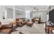 Inviting living room features a leather sofa, fireplace, ceiling fan, and wood floors at 106 Big Cotton Trl, Mcdonough, GA 30252