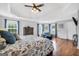 Bright main bedroom offers a tray ceiling, hardwood floors, and large windows with blue curtains at 106 Big Cotton Trl, Mcdonough, GA 30252