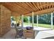 Inviting outdoor patio area with comfortable seating, perfect for relaxing and entertaining under the home's wooden deck at 106 Big Cotton Trl, Mcdonough, GA 30252