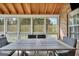 View of the screened porch featuring vaulted ceilings and a table with views of the backyard at 106 Big Cotton Trl, Mcdonough, GA 30252