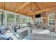 Cozy screened porch with brick wall, tv, and seating area with vaulted ceilings and backyard views at 106 Big Cotton Trl, Mcdonough, GA 30252