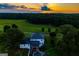 Beautiful aerial view of estate home with pool, screened porch, and lush landscaping at sunset at 1074 Glenloch Rd, Roopville, GA 30170