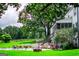 Large backyard with lush lawn, a fire pit, and patio seating at 1074 Glenloch Rd, Roopville, GA 30170