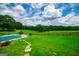 Beautiful backyard with a swimming pool, lush green lawn, and wooden fence at 1074 Glenloch Rd, Roopville, GA 30170