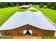 Aerial shot of a brown barn, open doorway with curtains, surrounded by green grass at 1074 Glenloch Rd, Roopville, GA 30170