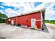 Side of the red barn with 'Knock for Service' sign near the back door at 1074 Glenloch Rd, Roopville, GA 30170