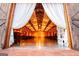 View of interior of barn venue, complete with tables, chairs, lighting and draped fabric at 1074 Glenloch Rd, Roopville, GA 30170