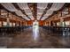 Expansive barn interior setup with tables, chairs, and white drapery from the ceiling at 1074 Glenloch Rd, Roopville, GA 30170