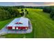 Red barn with white roof and doors sits next to green pasture at 1074 Glenloch Rd, Roopville, GA 30170