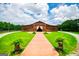 Large barn with a lush lawn, mature trees, and a brick path at 1074 Glenloch Rd, Roopville, GA 30170