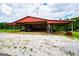 Open barn has a tractor parked inside; the area is covered with gravel at 1074 Glenloch Rd, Roopville, GA 30170