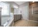 Modern bathroom featuring a soaking tub, glass-enclosed shower, and vanity with double sinks at 1074 Glenloch Rd, Roopville, GA 30170