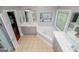Modern bathroom featuring a soaking tub, glass-enclosed shower, and vanity with double sinks at 1074 Glenloch Rd, Roopville, GA 30170